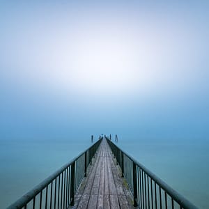 Roland Seichter Fotografie - Minimalistische Fotografie - Ein Dampfersteg am Ammersee führt in die Mitte des Bildes